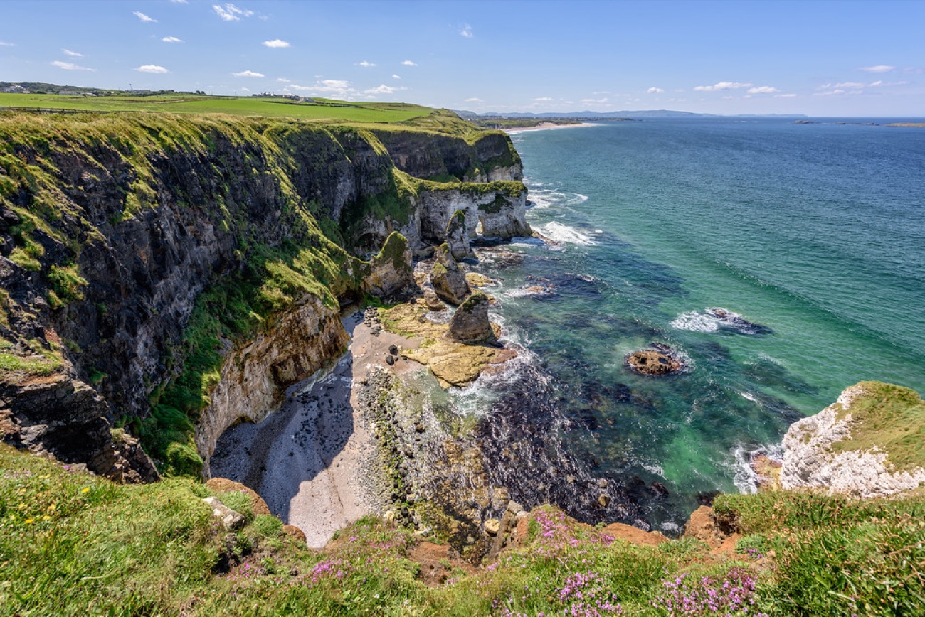 The clifftop coastal path at Whiterocks looking down over the cliffs and the turquoise sea toward Portrush