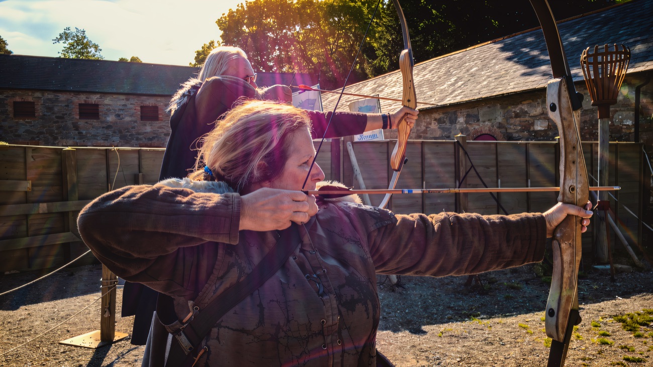 Drawing a longbow in warm backlight at the Winterfell archery range